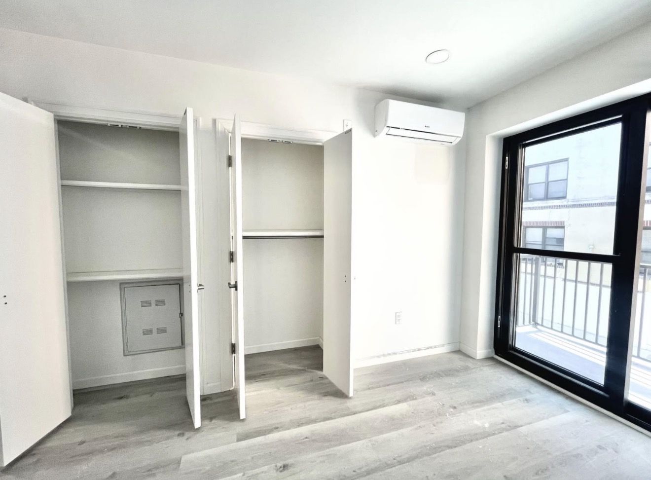 Common-area closets with built-in shelving, split-unit climate control, and balcony access — the master bedroom closet matches this same style